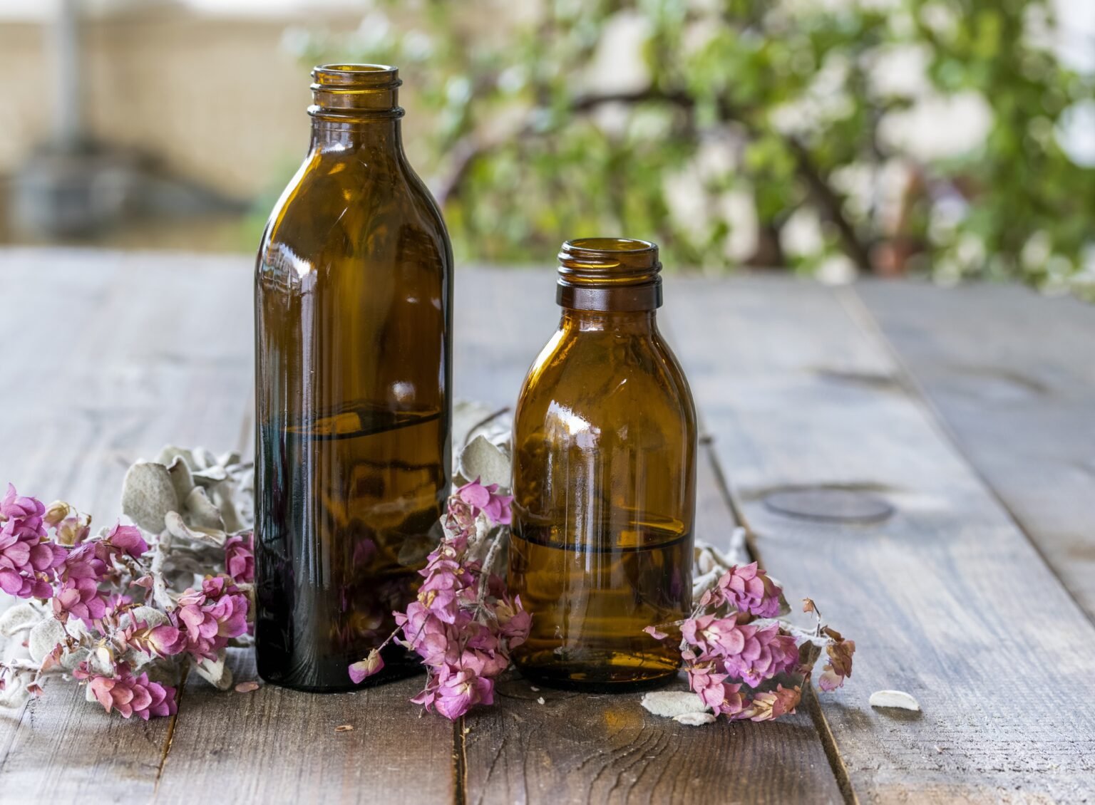 atik fragrance oil bottles with dry flowers around the bottles